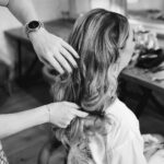 A woman getting her hair done in a black and white photo.